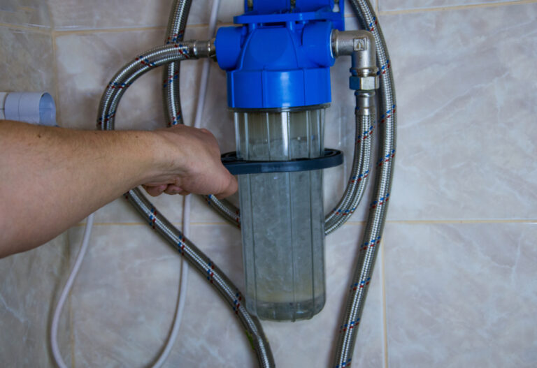 A & A Water Solutions Expert Installing a Home Water softener to the wall.